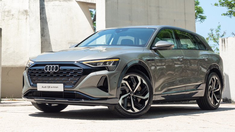 The Audi Q8 E-Tron parked next to a cement structure.