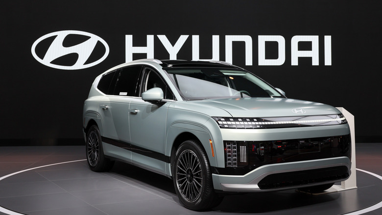 A light gray Hyundai Ioniq 9, the Hyundai logo and name in the background