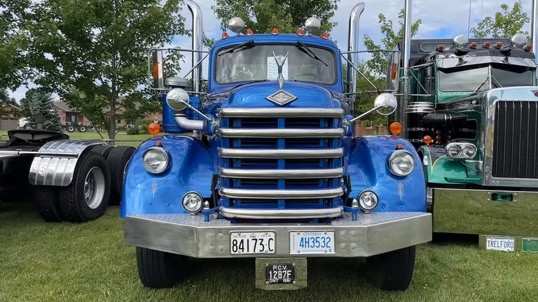 A shining dark blue Diamond T 921 truck before the facelift parked at an outdoor show