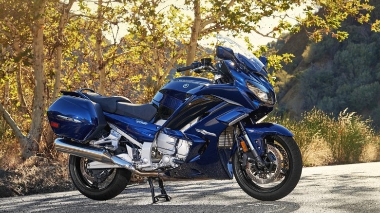 A blue Yamaha FJR1300 with a tree behind it.