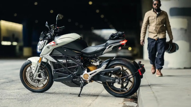A white Zero SR/F motorcycle with man in background