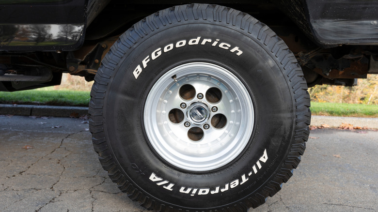 A close up shot of a BF Goodrich all terrain tire on a pickup truck