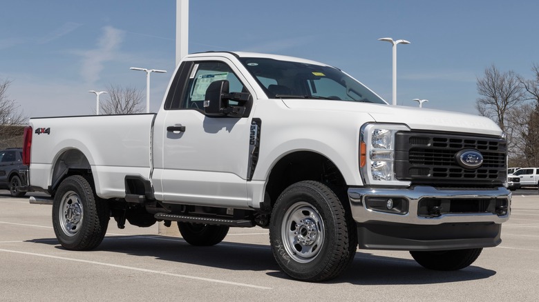A white Ford F350 from the 2023 model year on display at a dealer lot outside