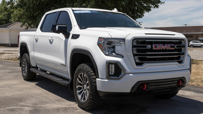 A white GMC Sierra AT4 pickup truck parked outside a dealership