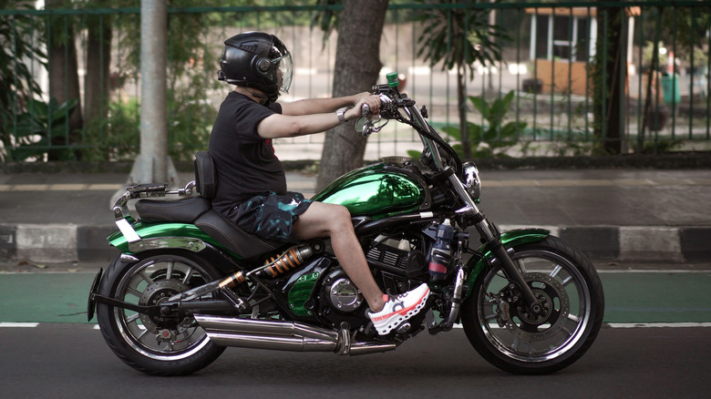 Rider driving green cruiser motorcycle