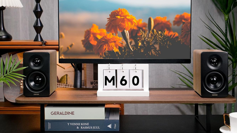 A pair of Edifier speakers on a TV stand flanking a TV