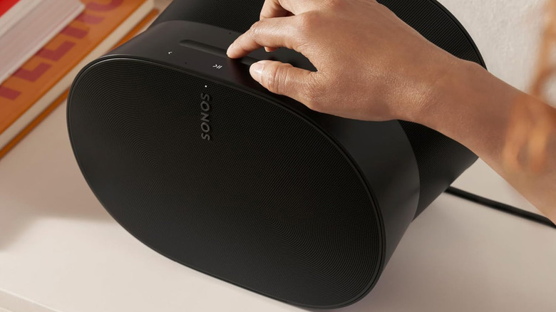 A person turning on a Sonos Era 300 speaker