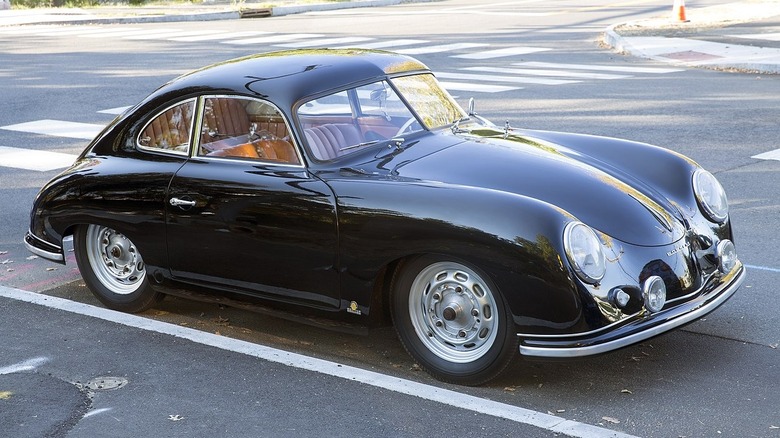 Silver Porsche 356 parked in front of water