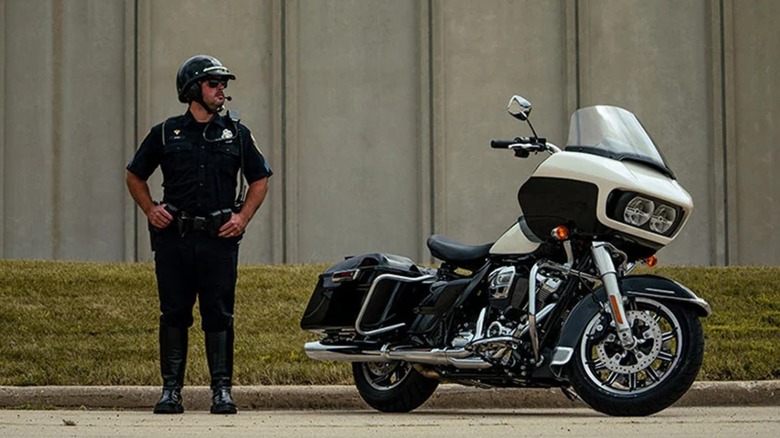 Harley Davidson Police Road Glide motorcycle with a policeman standing next to it