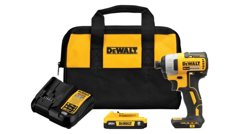 A DeWalt bag next to a charger, a battery and teh 20V Max 1/4-Inch Impact Driver