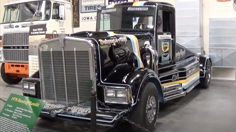 The 1978 Kenworth "Bandag Bandit" show truck on museum display, showing off its black paint with blue-gold stripes, huge chrome grille, and side pipes.