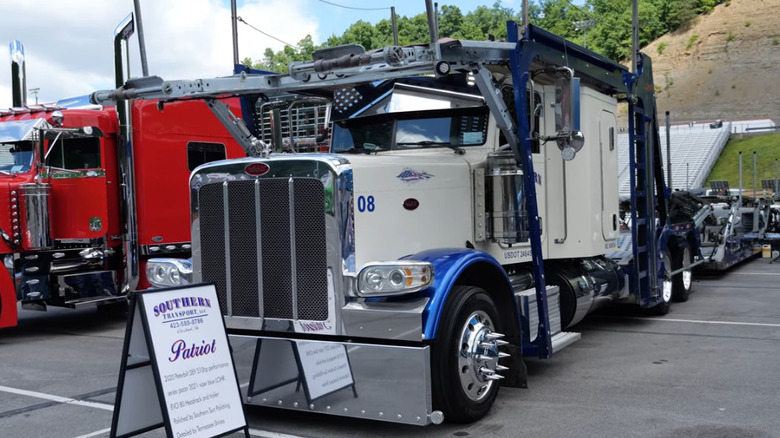 A custom Peterbilt car hauler named "Patriot," painted white with blue accents and chrome details.