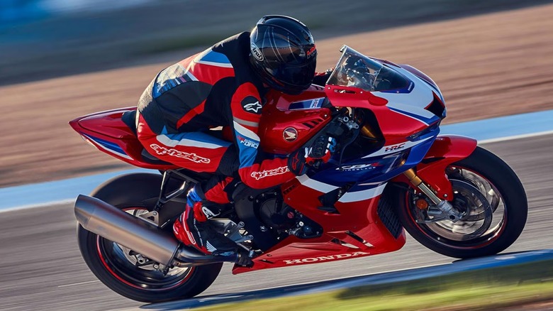 a Honda CBR1000RR-R Fireblade SP quickly driving through a race track