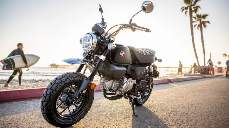 a rider sitting on a Honda Monkey while stopped at an intersection