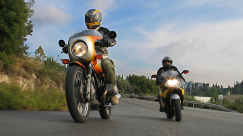 two motorcycles turning on a scenic road