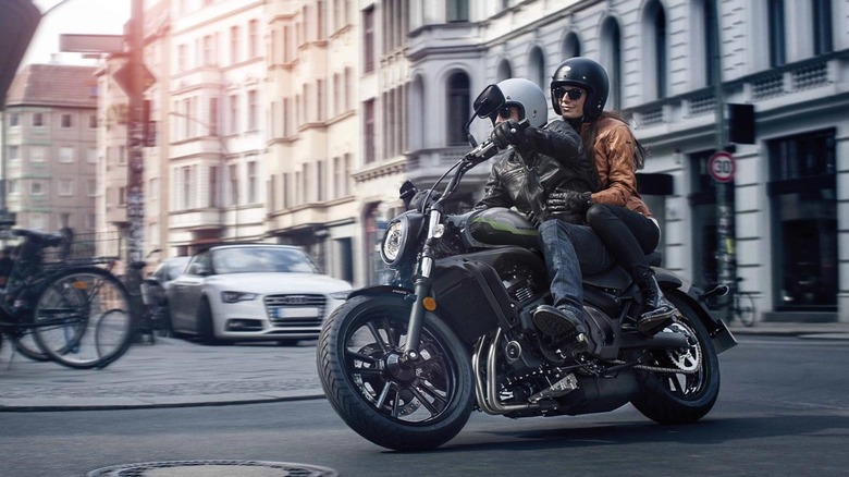 Couple riding around city on Kawasaki Vulcan S 650 motorcycle