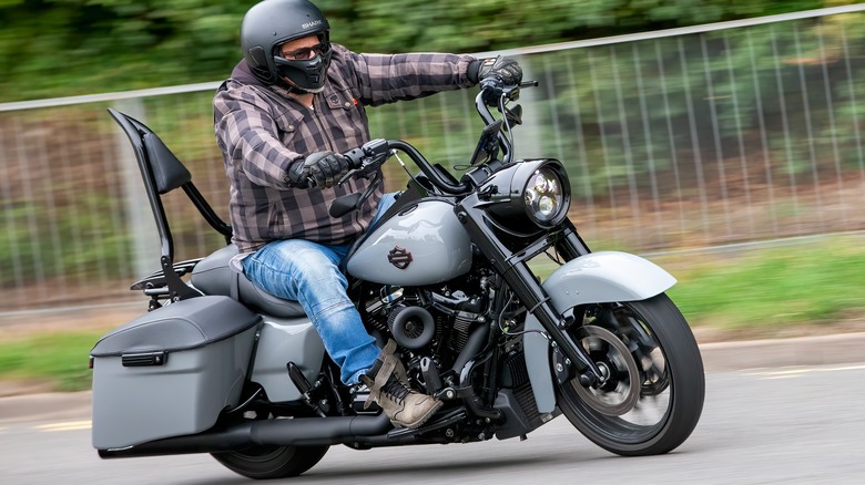 A grey 2024 Harley Davidson Road King Special Edition being ridden down a backroad.