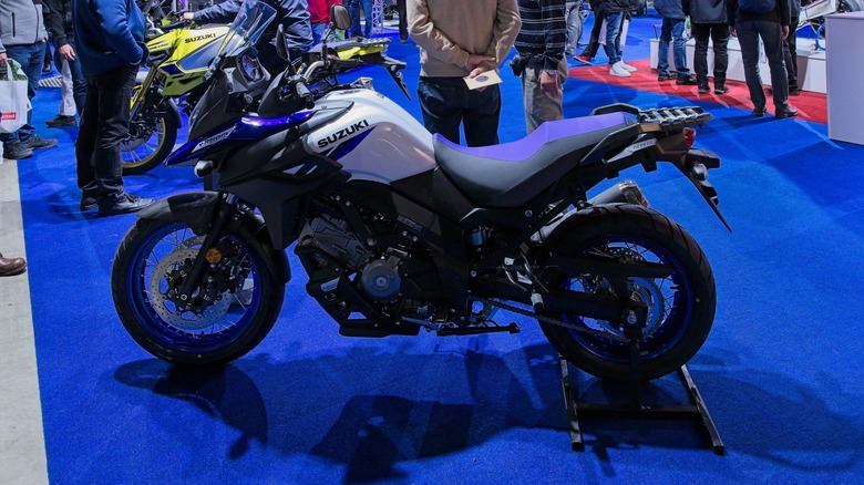 A white and black V-strom 650 on display on blue carpet indoors