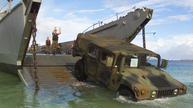 HMMWV backing onto landing craft utility in Guam