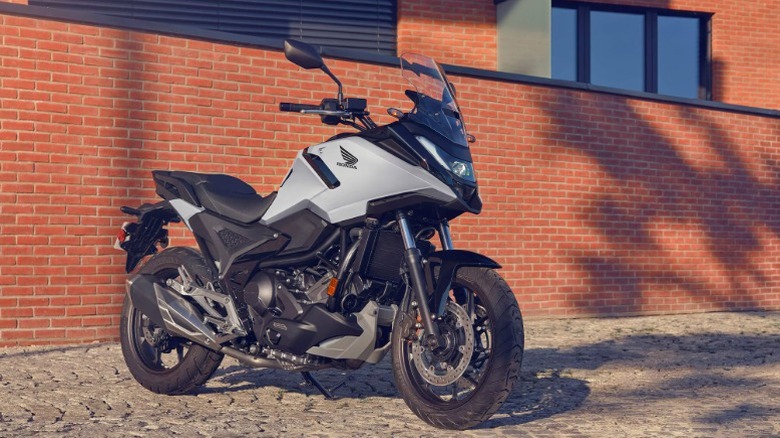 A Honda NC750X parked by a brick wall