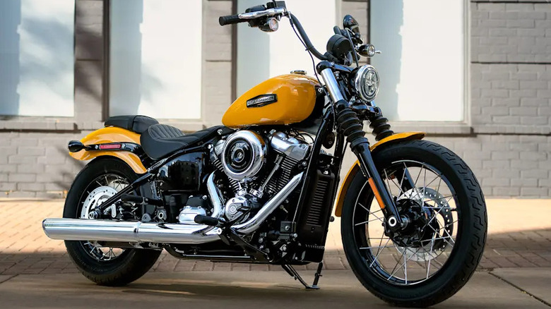 A 2025 Harley Street Bob finished here in vibrant yellow, parked upright with buildings visible in the back