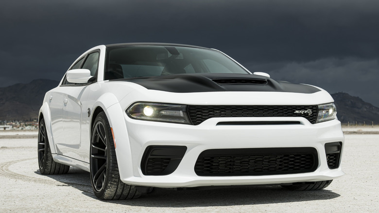 White Dodge Charger SRT Hellcat Redeye parked in a desert with dark skies