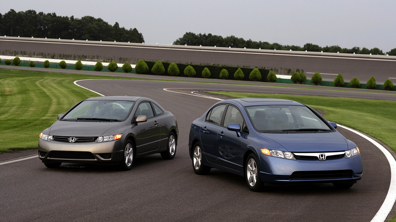 A blue 2007 Honda Civic sedan and bronze Honda Civic Coupe parked on track