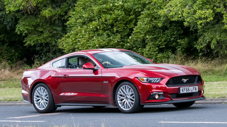 A red 2015 Ford Mustang driving