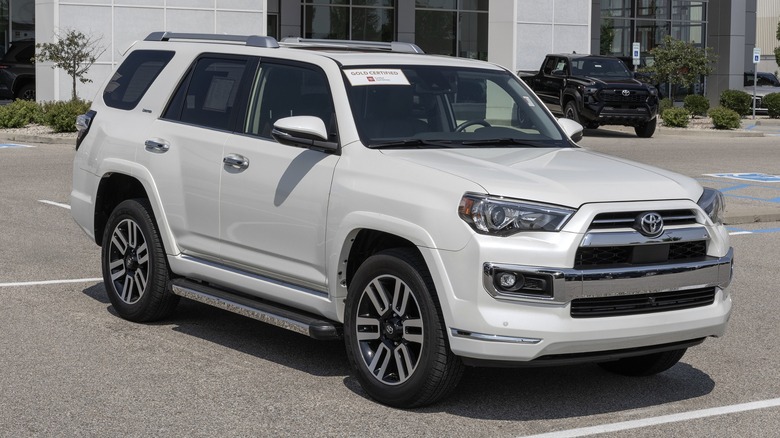 A white Toyota 4Runner parked in a lot with another Toyota in the background.