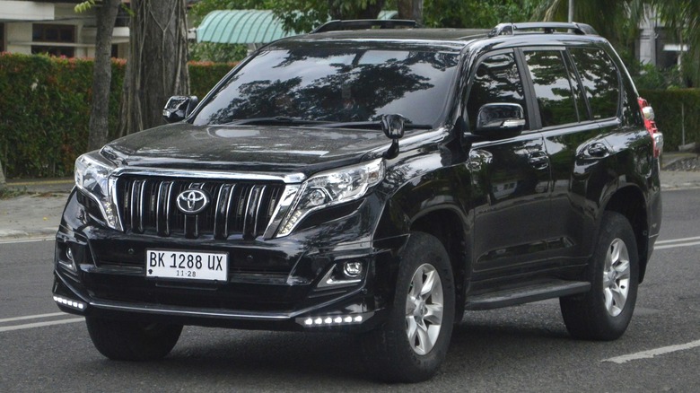 A black 2013 Toyota Land Cruiser Prado parked along the street.