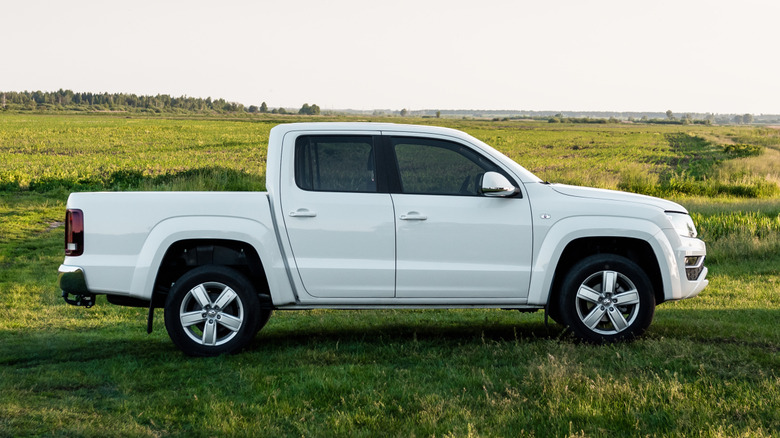 A Volkswagen Amarok in pear white seen moving along the side of a field in Ukraine