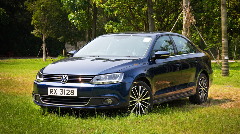 A black 2014 Volkswagen Jetta parked at the edge of a lot