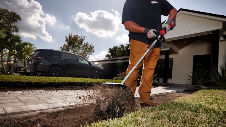 digging up soil with cultivator attachment