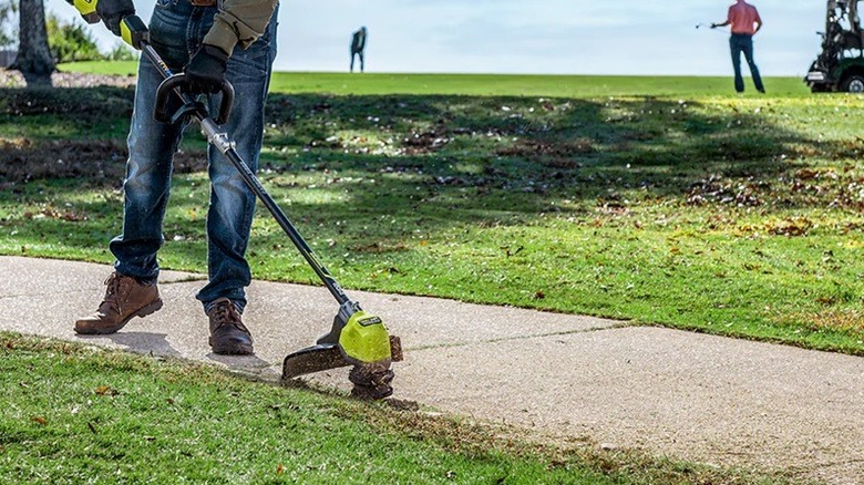 Person using Ryobi string trimmer