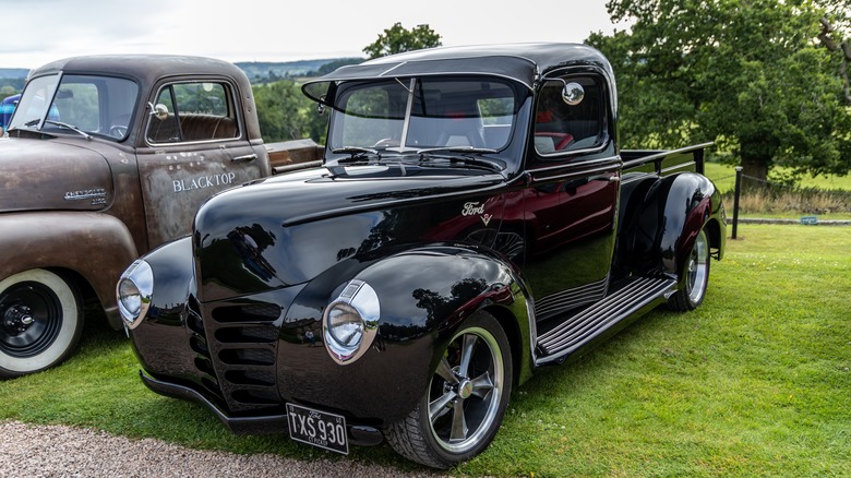 A restored black 1940 ford pickup at a display event in the UK