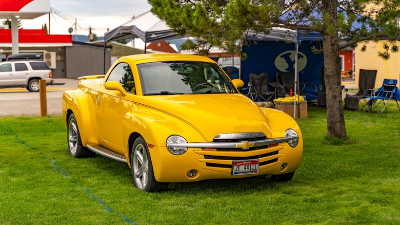 A yellow Chevrolet SSR roadster on display at a car show outdoors