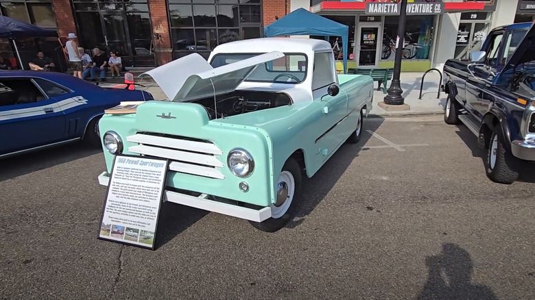 A mint-green Powell sport wagon pickup in its designated location at an outdoor car show