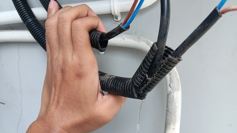 hand pulling wires that are wet