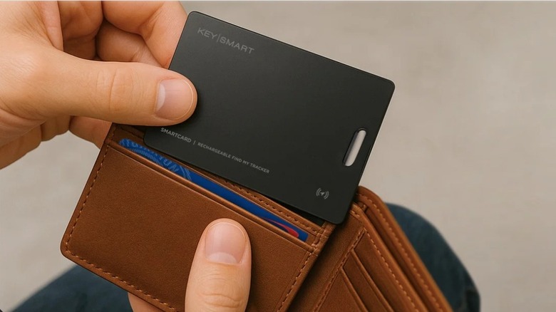 Hand sliding a black card into a tan wallet