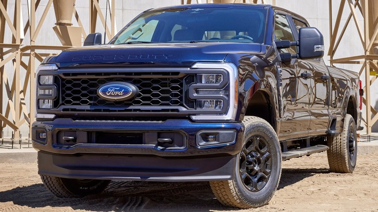 A black 2023 Ford Super Duty F-250 XL is parked at an industrial site.
