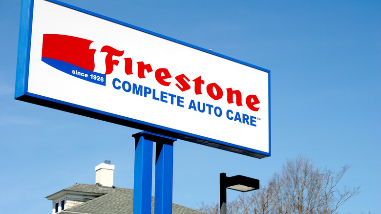 A billboard mounted on a pole showing the Firestone CAC logo on a white background