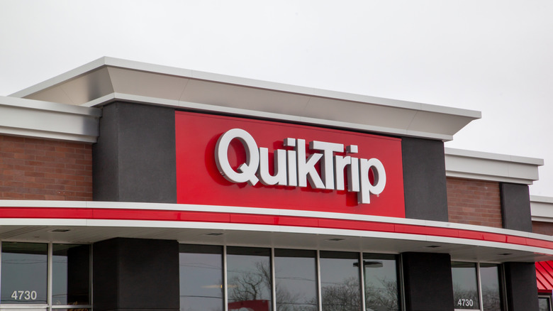 A QuikTrip logo on the signature red background above the glass entrance to one of the stores