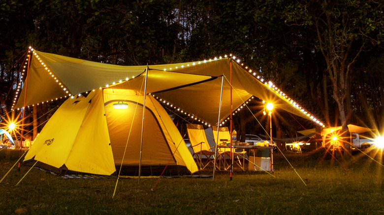 A yellow camping tent adorned with string lights.