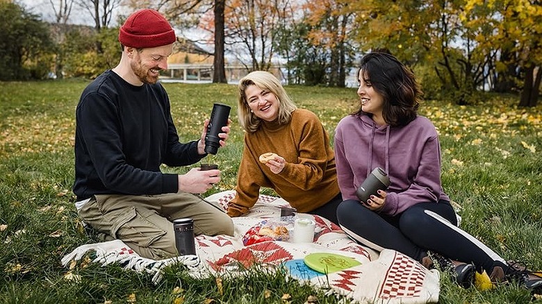 People enjoying picnic, making coffee with the OutIn handheld espresso machine.