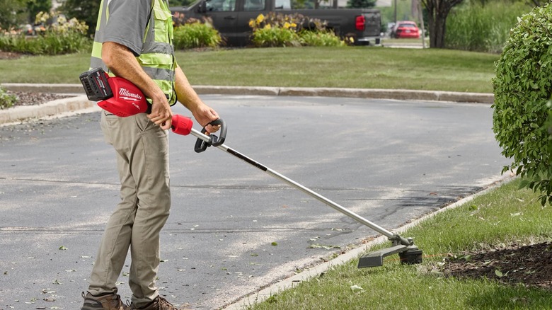 cutting grass with Milwaukee trimmer