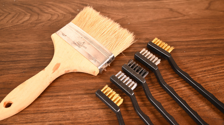 A smattering of wire brushes with a paint brush.