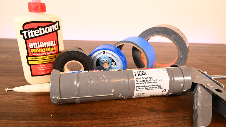 Various tapes, glues, and caulk on a table.
