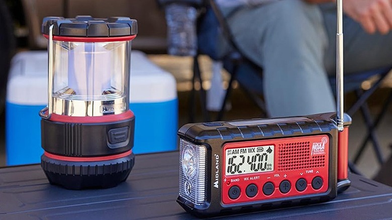 Emergency radio placed alongside a portable lantern.