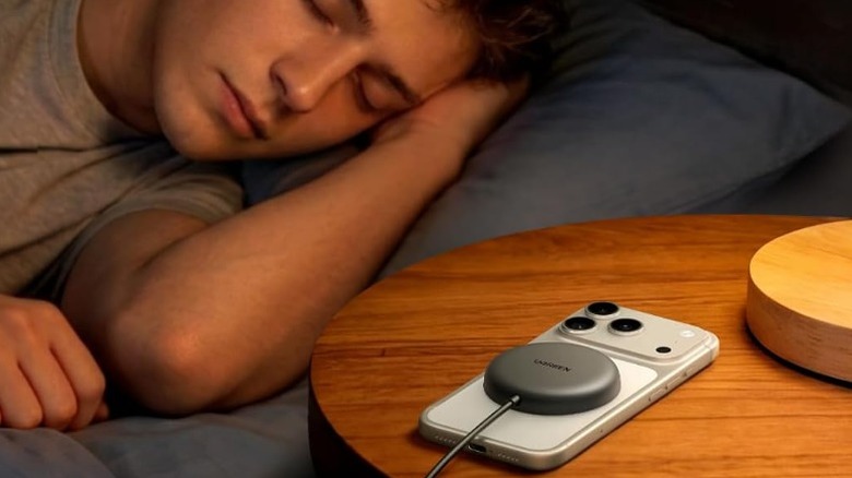 Person sleeping while charging an iPhone with a Ugreen wireless charger