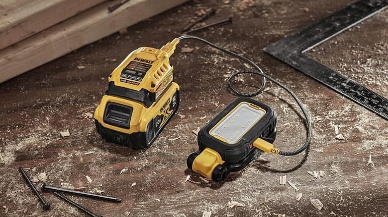 A task light connected to a charger at a worksite.